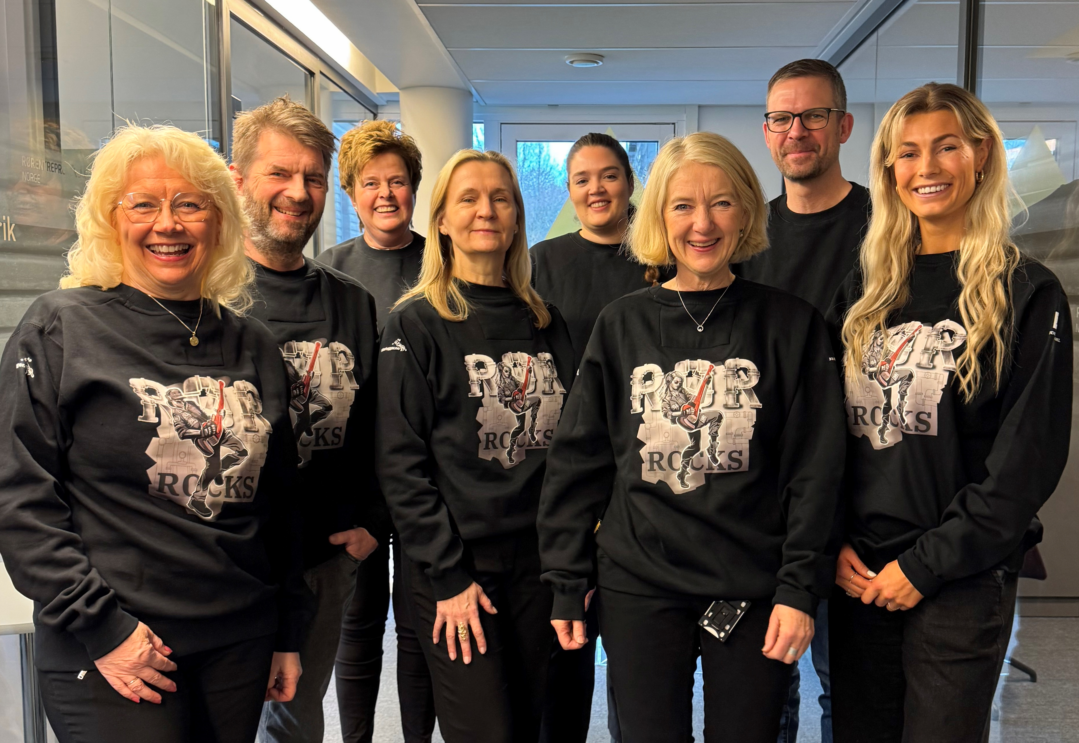Bilde av Ingebjørg, Are, Anne Lise, Kjersti, Oda, Marianne, Stein og Kaja. Alle har på seg sorte gensere med trykket "Rør Rocks"