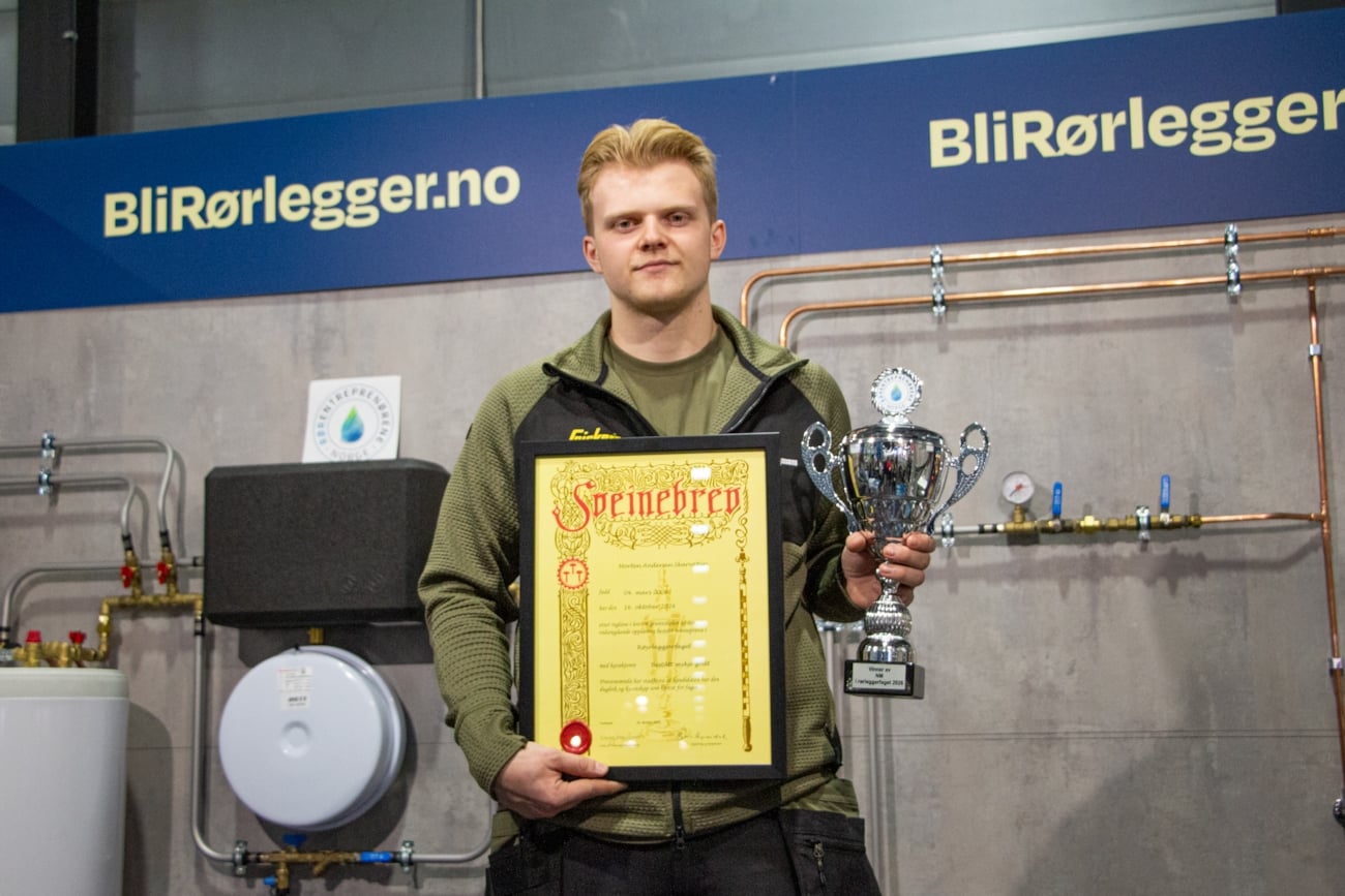 Morten Andersen Skarvatun med vinnerpokal og svennebrev i hånden.