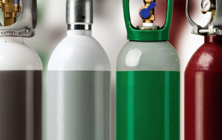 Bilde av gassflasker i forskjellige farger.