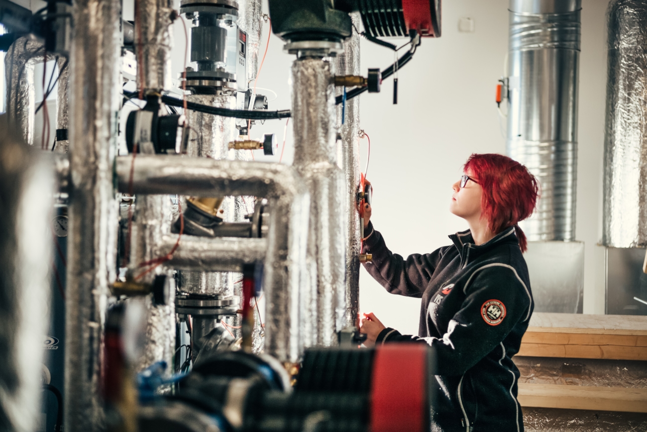 Illustrasjonsbilde for KEM Fagskole. Kvinnelig rørlegger jobber med et anlegg. Foto: Ilja Hendel